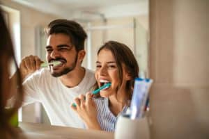 two people brushing their teeth