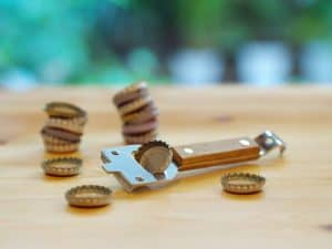 a bottle opener with bottle caps scattered around