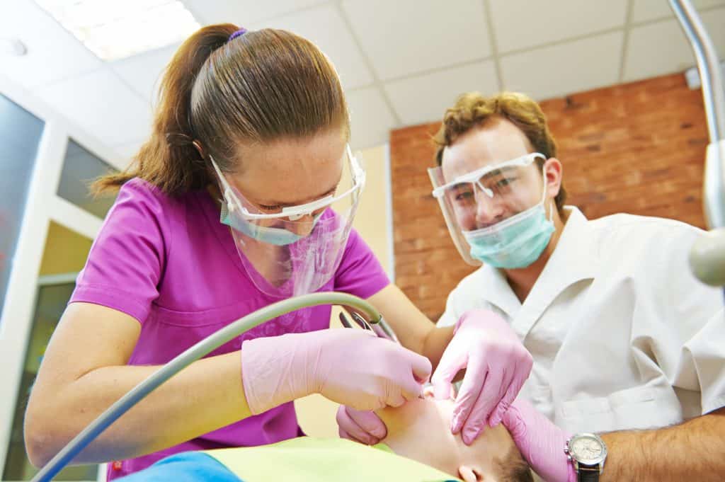 Feel Better About Oral Sedation child dentist treat boy teeth under sedation with dental curing ultraviolet light equipment