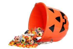 isolated child halloween pumpkin bucket spilling candy on white background