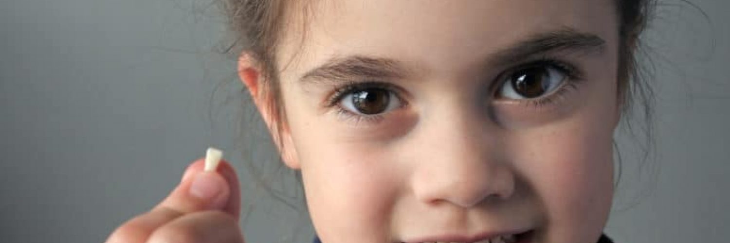 child holding her lost tooth