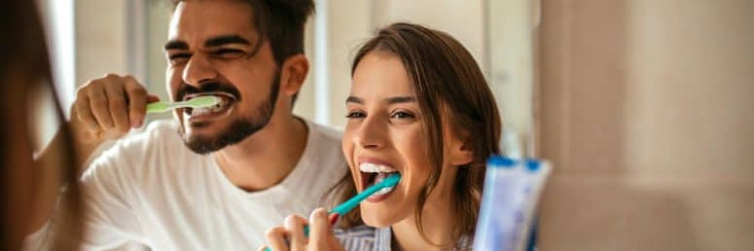 two people brushing their teeth