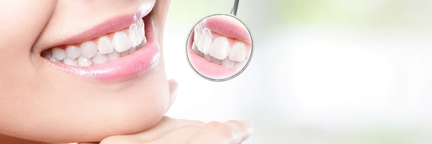 Healthy woman teeth and a dentist mouth mirror with nature green background, asian beauty