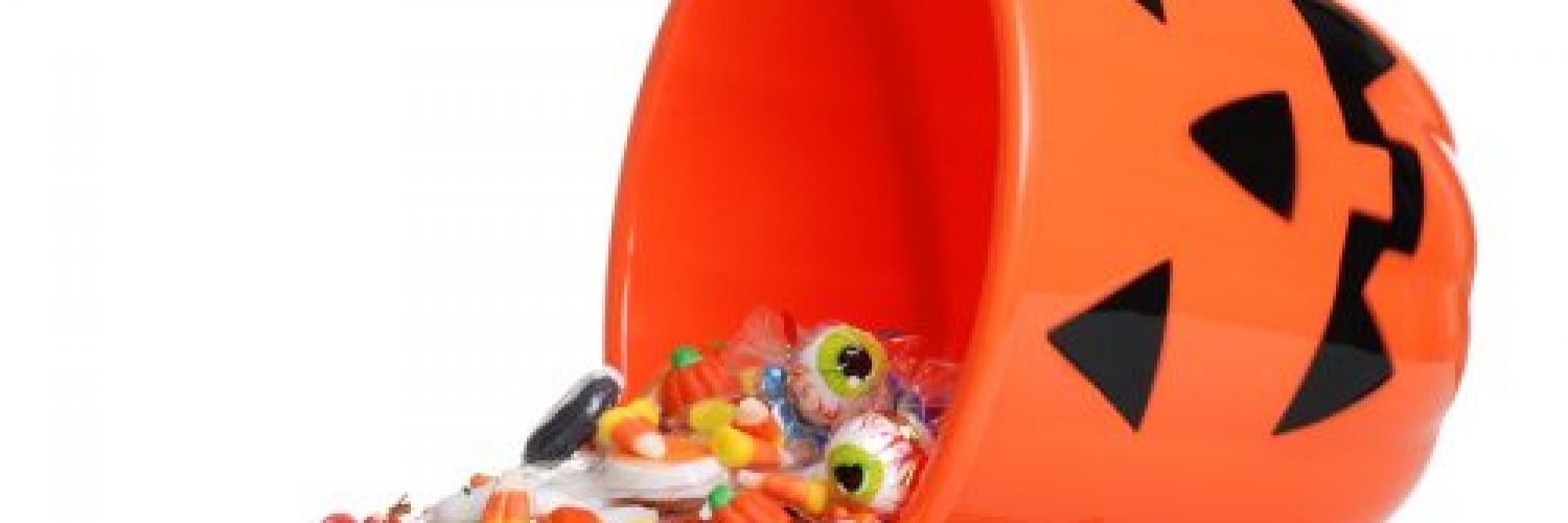 isolated child halloween pumpkin bucket spilling candy on white background