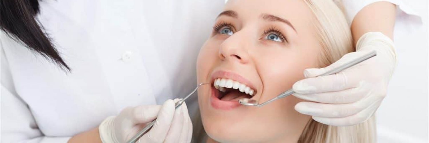 Woman having her teeth examined by dentist