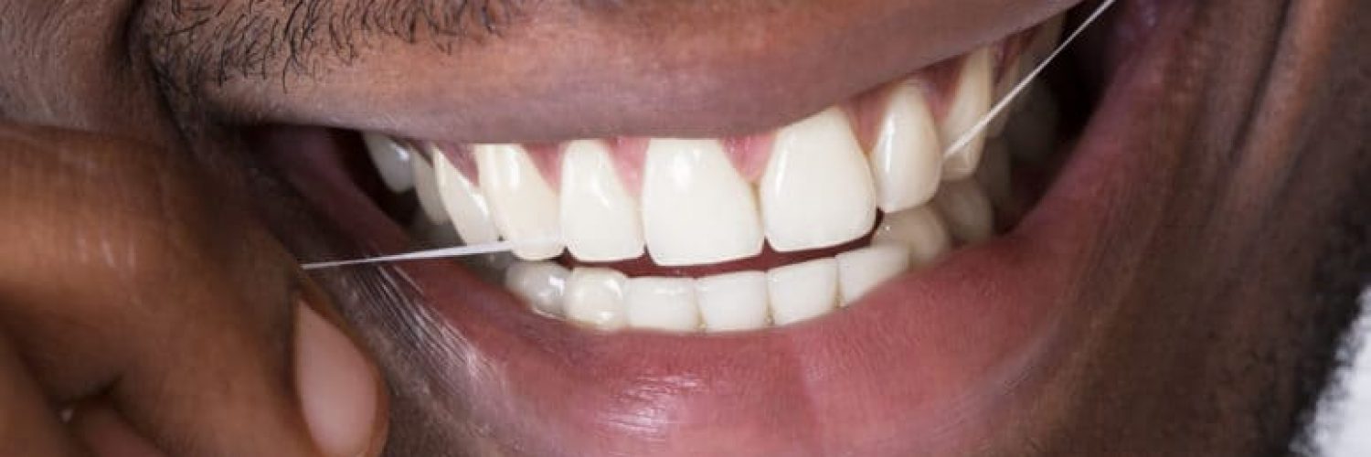 close-up of man flossing teeth