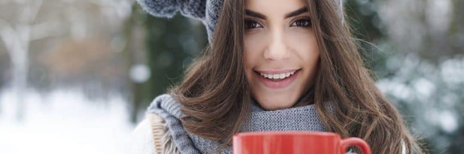 Woman drinking a hot drink in cold air.