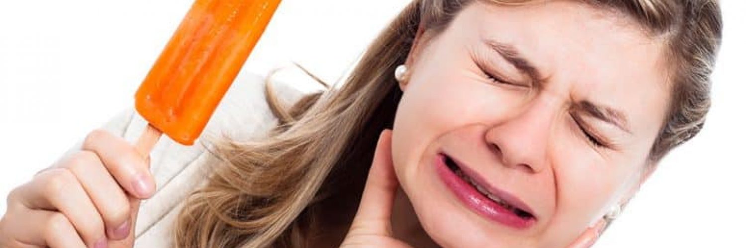 woman with sensitive teeth eating popsicle