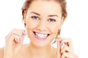 A picture of beautiful woman flossing her teeth over white background