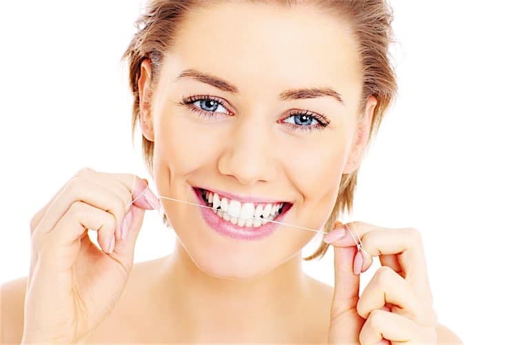 Teeth flossing A picture of beautiful woman flossing her teeth over white background