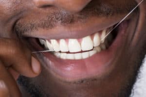 close-up of man flossing teeth