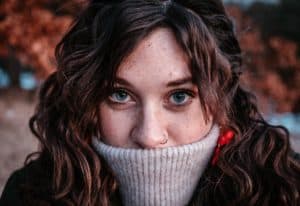 woman covering mouth with turtleneck