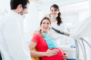 pregnant woman speaking with her dentist about pregnancy gingivitis