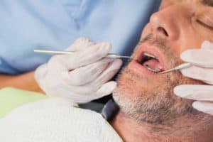 man under conscious sedation during dental cleaning